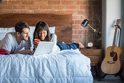 Image: young couple in apartment researching earthquake insurance