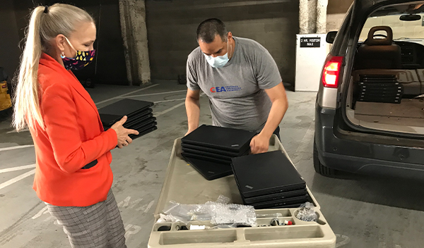 Image: The CEA team helps load the laptops