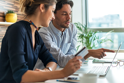 Image: Man and woman looking over a document at a table