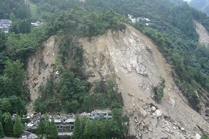 Image: Large landslide down a hill with houses destroyed