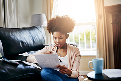 woman looking thoughtfully at earthquake insurance bill