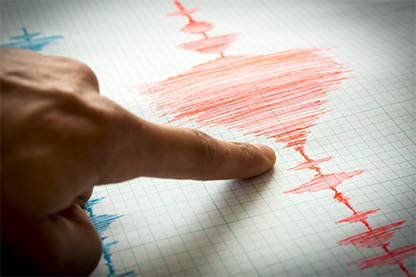 Image: finger pointing to a seismograph in red ink